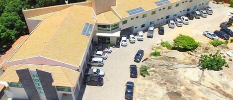 Un hotel con estacionamiento y un edificio con techo inclinado.