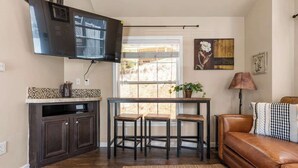 A compact living space with a kitchen, dining area, and seating area. - Woodland Peak Tiny Lodge (Woodland Park)