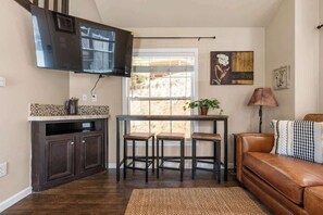 A compact living space with a kitchen, dining area, and seating area. - Woodland Peak Tiny Lodge (Woodland Park)