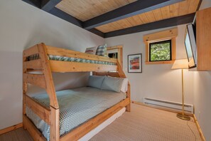 A bunk bed with a checkered bedspread, a window with a view, a floor lamp, and a radiator. - Harbor Point at Star Harbor - Condo with Pool, Tennis and Pier Access (Tahoe City)