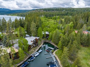 A lakeside property with a dock, boats, and a building with a large roof.