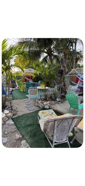 A tropical outdoor seating area with wicker furniture, a hammock, and a small table. - Beautiful RV in Big Pine Key, Great outdoor area. Short drive to Key West (Big Pine Key)