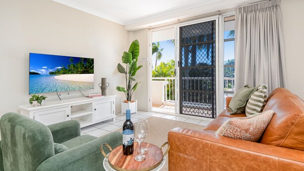 A living room with a TV, sofa, and coffee table. - Heart of Townsville on the Harbour (Townsville City)