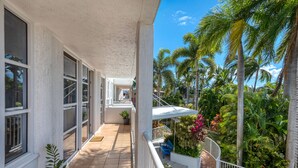 A balcony with a view of palm trees and a tiled floor. - Heart of Townsville on the Harbour (Townsville City)