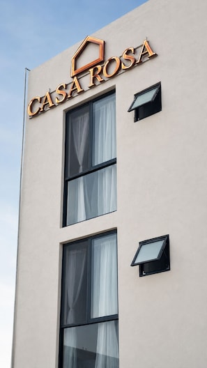 A building with a sign reading 'CASA ROSA' and two windows with curtains. - Hotel Casa Rosa (Aguascalientes)