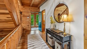 A wooden interior hallway with a mirror, a lamp, and a console table. - Escape to Summit View Lodge in Mountaintop, a spacious pet-friendly retreat for 14! (McHenry)