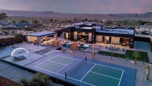 A modern house with a tennis court, pool, and outdoor seating area. - Skyhaven Luxe - Pool/Spa Pickleball Sauna (Joshua Tree)