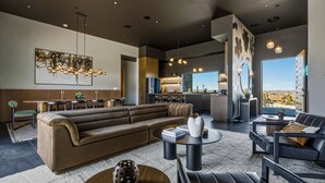 A modern living room with a sectional sofa, a coffee table, and a dining area with a table and chairs. - Skyhaven Luxe - Pool/Spa Pickleball Sauna (Joshua Tree)