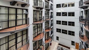 A multi-story hotel with balconies, a courtyard with seating, and a modern architectural design.