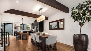 A modern kitchen with a dining area, wooden floors, and a large potted plant. - VIEW from 2 Rooftop Decks, Walk to Kerry Park, Minutes to DT and Space Needle (Seattle)