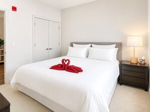 Quarto de hotel com uma cama, mesa de cabeceira, abajur e armário.
