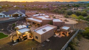 Un barrio residencial con varias casas, una piscina y una vista despejada de montañas a lo lejos.