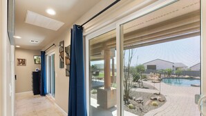 Un pasillo con una puerta de cristal que da a una zona de piscina.