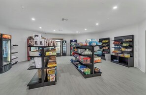 Ein sauberer, gut beleuchteter Laden mit Regalen voller verschiedener Produkte, darunter Snacks und Getränke.