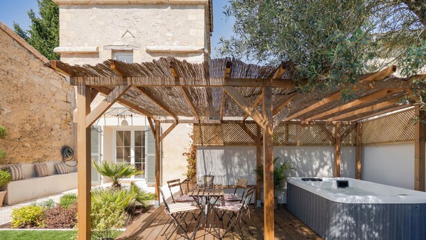 A wooden deck with a hot tub, outdoor seating, and a pergola. - Tour Vinea - Private Jacuzzi & 4K Cinema near Bordeaux (Villenave-d'Ornon)