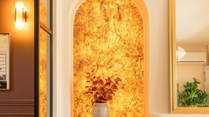 A room with a wooden floor, a grey cabinet, a wall-mounted light, and a framed mirror. - Tour Vinea - Private Jacuzzi & 4K Cinema near Bordeaux (Villenave-d'Ornon)