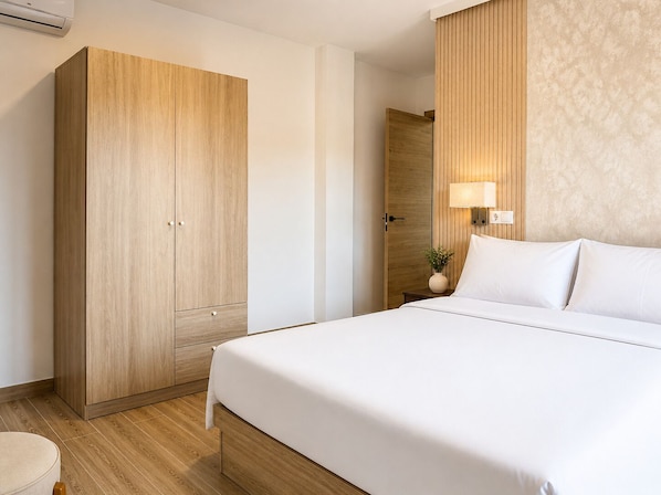 A hotel room with a bed, wooden wardrobe, bedside table, lamp, and a small plant. - Collection Las Ventas (Madrid)