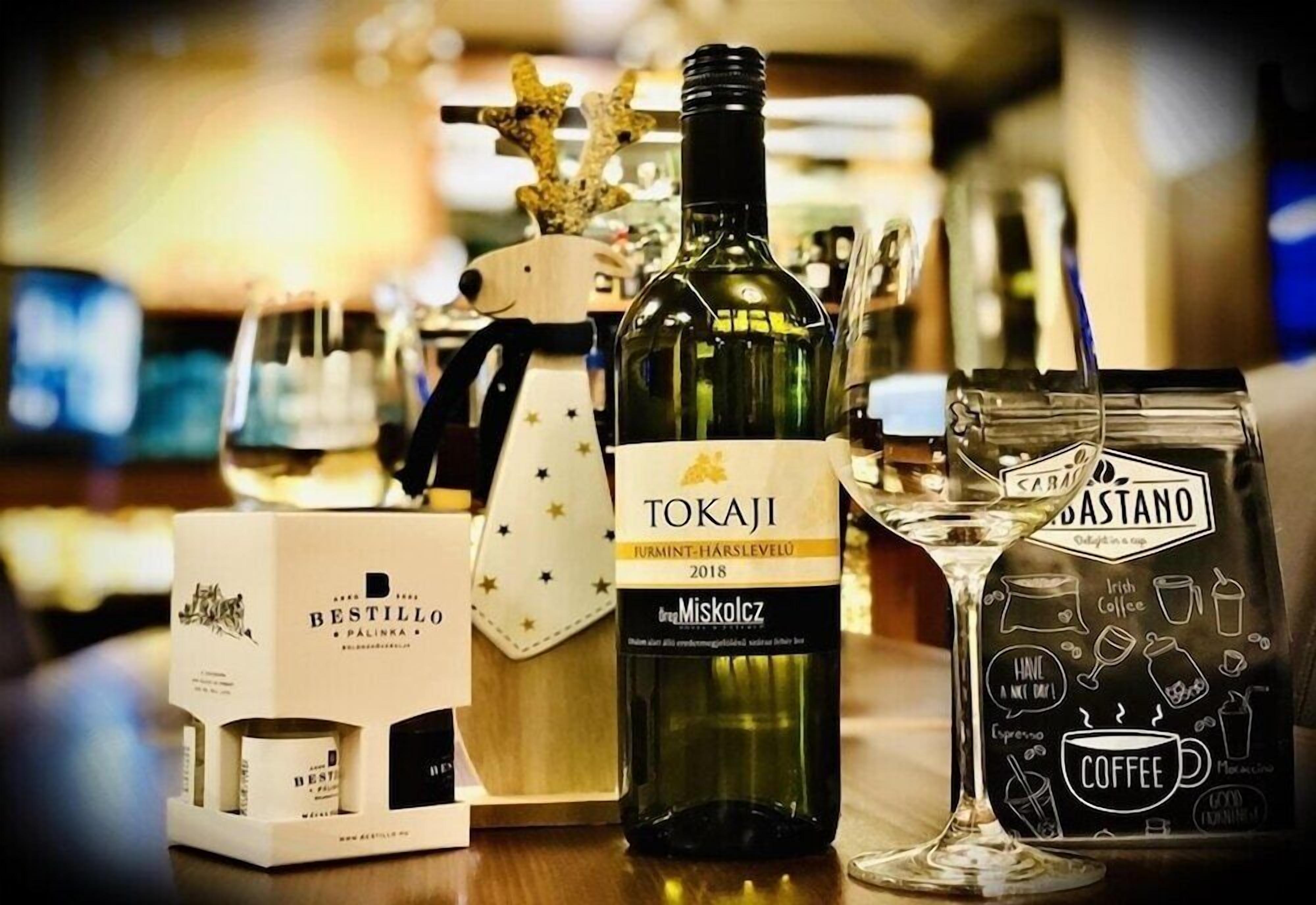 A bottle of Tokaji wine, a coffee bag, and a Bestillo box on a table.