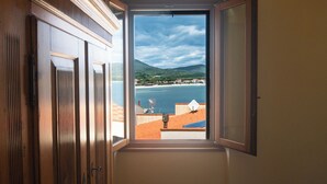 Un dormitorio con vista a una playa y colinas.