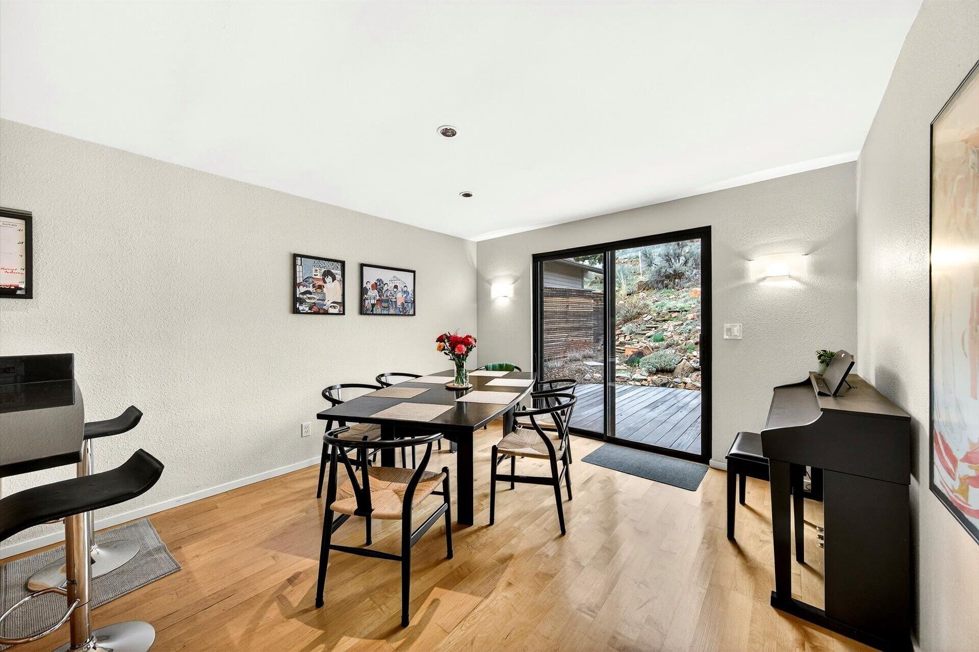 A dining area with a table, chairs, and artwork on the walls.