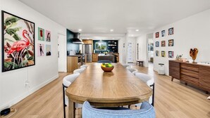 Un comedor moderno con una mesa de madera, sillas y un bol de fruta.
