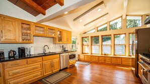 A spacious kitchen with wooden cabinets, a built-in oven, and large windows. - Riverside Holiday Home Sleeps 10 (Anderson)