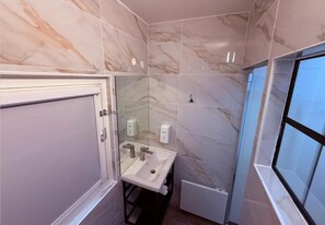 A bathroom with a marble wall, a sink, a mirror, and a window. - Formule1 Charleroi (Charleroi)