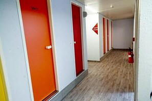 A corridor with doors marked 'WC' and a fire alarm sign. - Formule1 Charleroi (Charleroi)