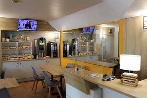 A modern kitchen with built-in appliances, a dining area with chairs, and a TV mounted on the wall. - Formule1 Charleroi (Charleroi)