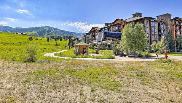 Un hotel con vista sulle montagne, un edificio piccolo e un idrante rosso.