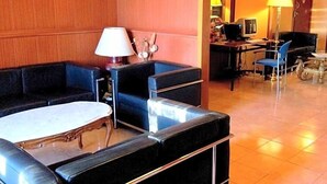A hotel lobby with a seating area, a desk, and a computer. - Toledano (Barcelona)