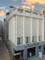 A building with the sign 'TAJ MAHAL HOTEL' and a signboard indicating 'NOW OPEN.'