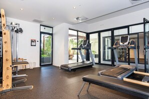 A gym with treadmills, a bench, and a weight machine. - Comfortable 2BR w/ Pool, Gym and BBQ | Free Parking (South Brisbane)