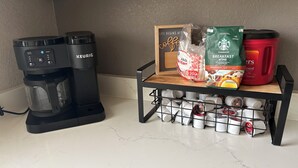 A kitchen with a Keurig coffee maker, a coffee grinder, a coffee maker, and a coffee bean storage unit.