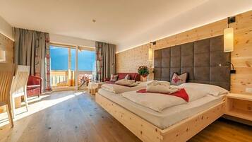 Quarto com cama grande, cabeceira de madeira, varanda e vista do céu.