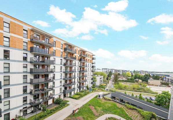 A multi-story residential building with balconies, a central courtyard, and a view of the surrounding area. - Warszawa Rakowska Homely Apartment (Warszawa)