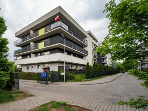 Ein mehrstöckiges Wohngebäude mit Balkonen, einem verschlossenen Eingang und einem gepflasterten Weg.