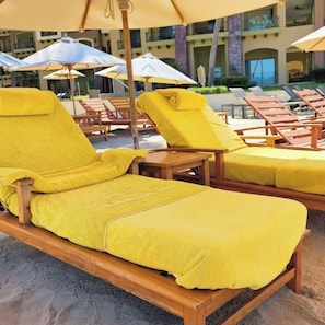 A poolside area with wooden lounge chairs and umbrellas. -  La Estancia Beach Resort and Spa Nuevo Vallarta (Nuevo Nayarit)