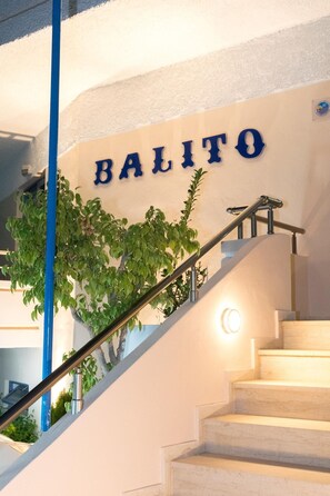 Eine Treppe mit einem Schild, auf dem 'BALITO' steht, und einem blauen Geländer.