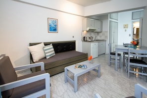 Ein modernes Wohnzimmer mit einer Couch, einem Couchtisch und einem Essbereich mit Tisch und Stühlen.