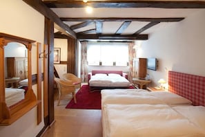 A bedroom with a large bed, a chair, a small table, and a television. - Karpfen (Eberbach)