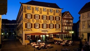 A historic building with a sign 'Hotel zum Sparren' and a courtyard with outdoor seating. - Karpfen (Eberbach)