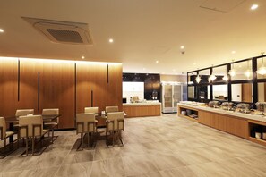 Un vestíbulo de hotel moderno con una zona de estar, una cocina y una recepción.