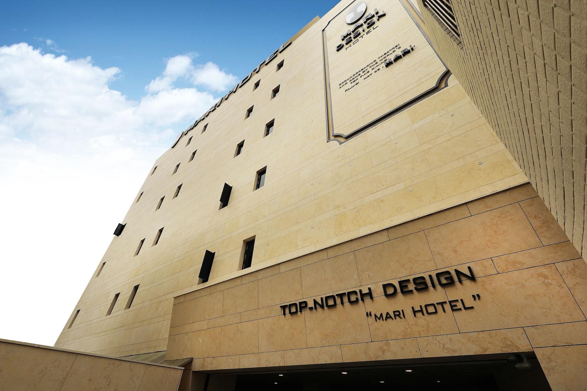 A hotel facade with a modern design, featuring a prominent sign for 'Top-Notch Design' and 'Mari Hotel'.