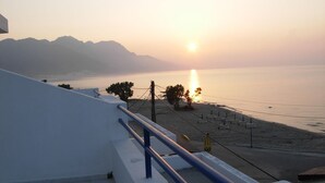 A staircase leading to a beach with a sunset in the background. - Philippos Studios & Apartments (Kos)