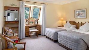 A bedroom with two beds, a desk, a chair, a lamp, and a window with curtains. - Kathleens Country (Killarney)