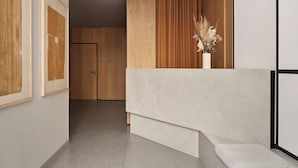 Ein modernes Interieur mit einer Holztür, einer Treppe und einer Vase mit Trockenblumen.
