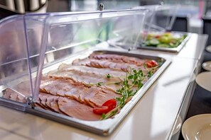 A buffet with sliced meats and garnishes, covered by clear plastic. - Land-gut-hotel Olympic (Wronki)