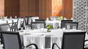 A restaurant with round tables, chairs, and a patterned wall. - Land-gut-hotel Olympic (Wronki)