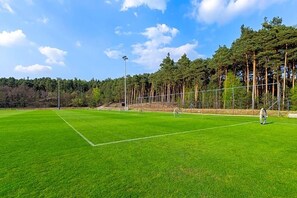 A soccer field with goalposts, surrounded by a fence and trees. - Land-gut-hotel Olympic (Wronki)